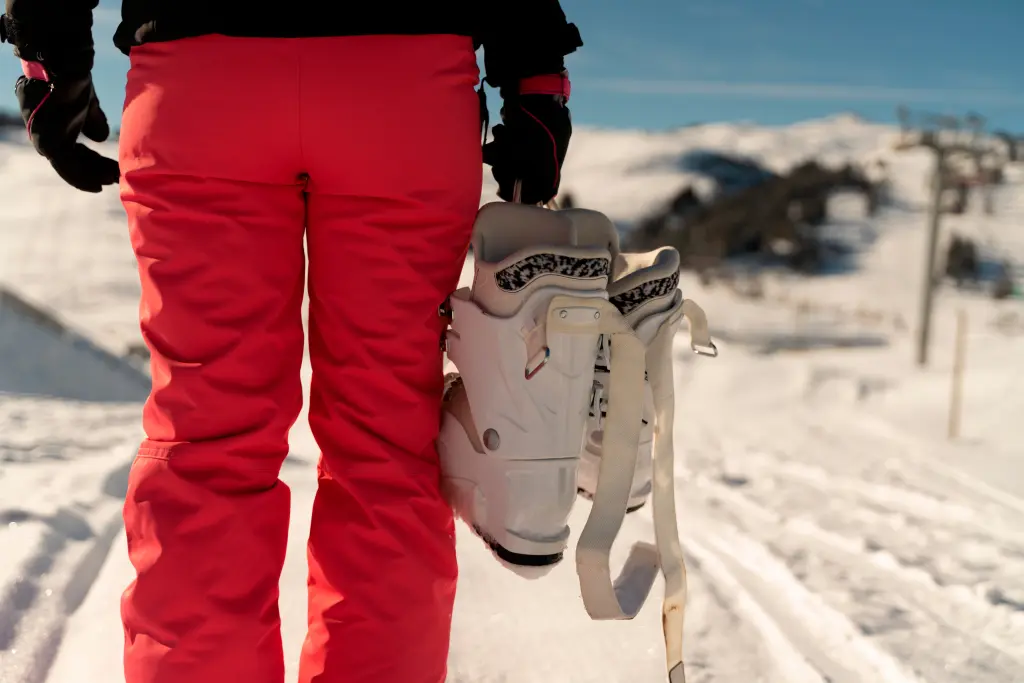 person-on-her-back-wearing-a-pink-ski-pant-holding-a-pair-of-ski-boots-in-a-ski-resort-in-the-alps.jpg person-on-her-back-wearing-a-pink-ski-pant-holding-a-pair-of-ski-boots-in-a-ski-resort-in-the-alps.jpg